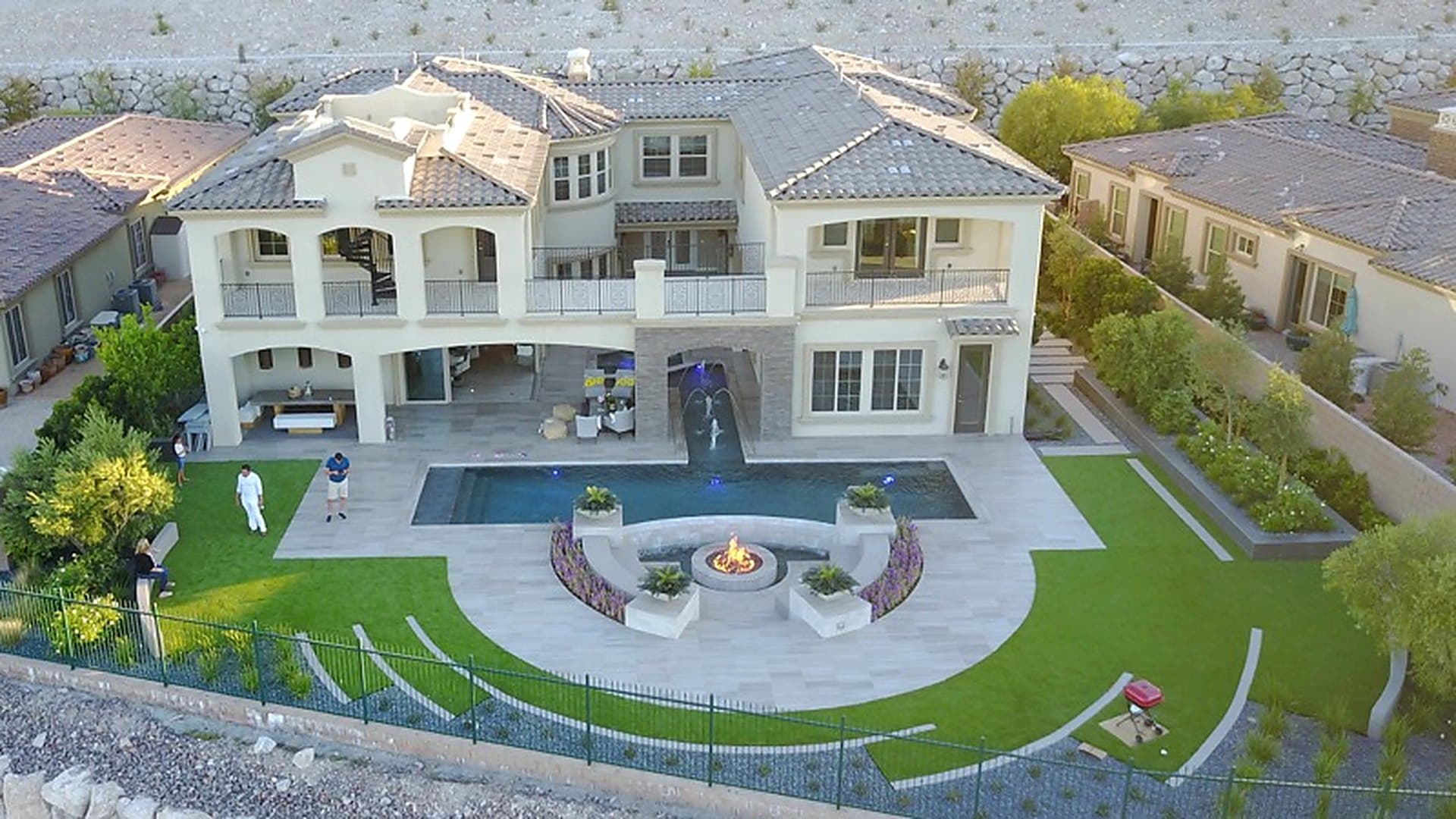 Aerial view of a Las Vegas backyard built by A1 — artificial turf lawn, paver decking, fire pit and pool