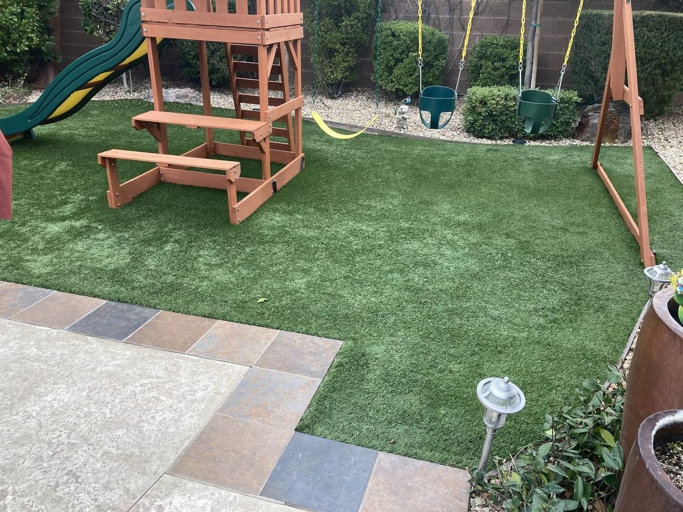 Backyard artificial turf lawn with a playset, installed by A1 for a Las Vegas family